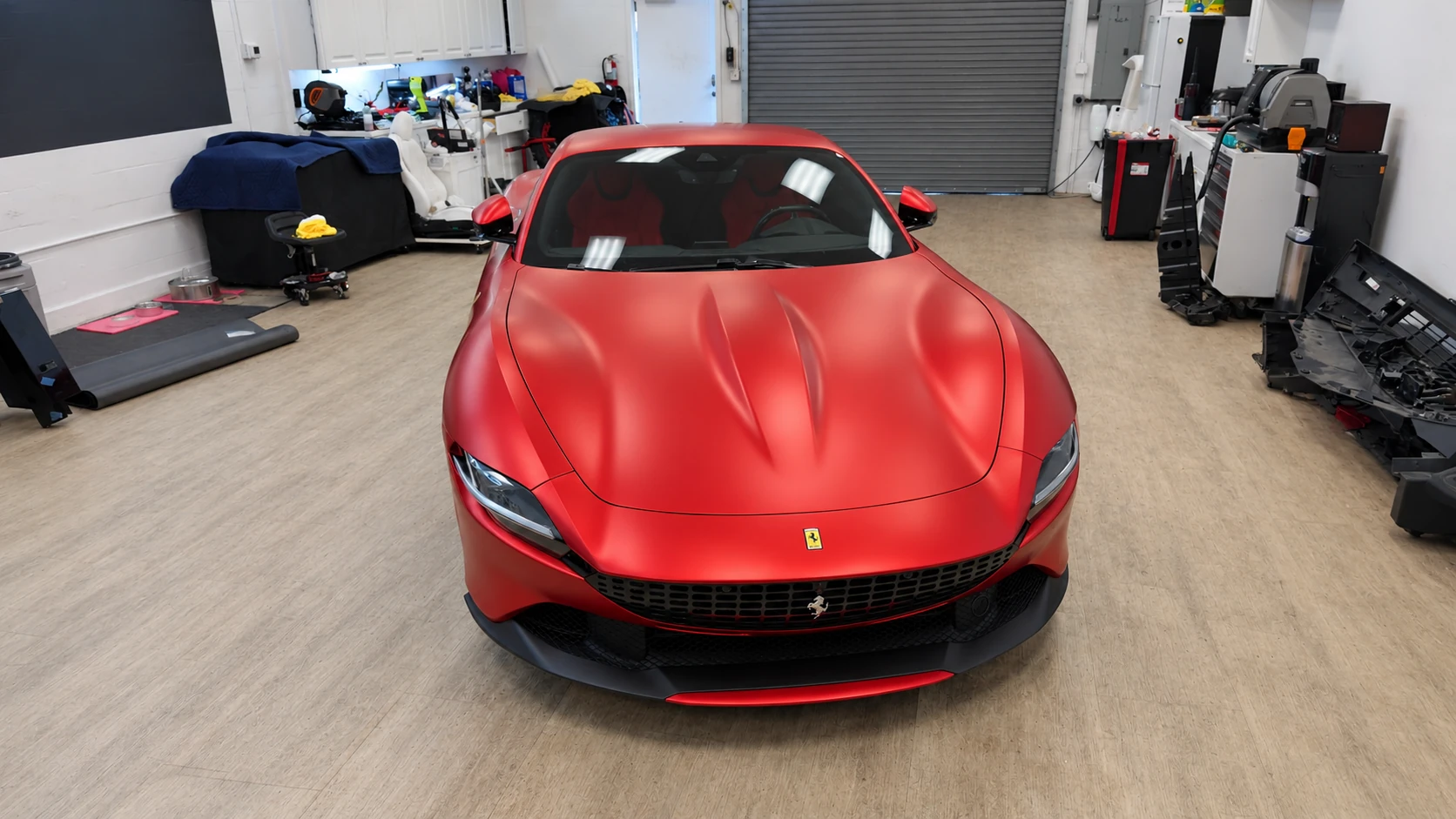 Head-on view of a Ferrari Roma with matte red PPF, showing the hood contours, headlights and black grille at Signature Customs.